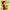 Shinchan dressed in a brown fox costume holding a corn cob.